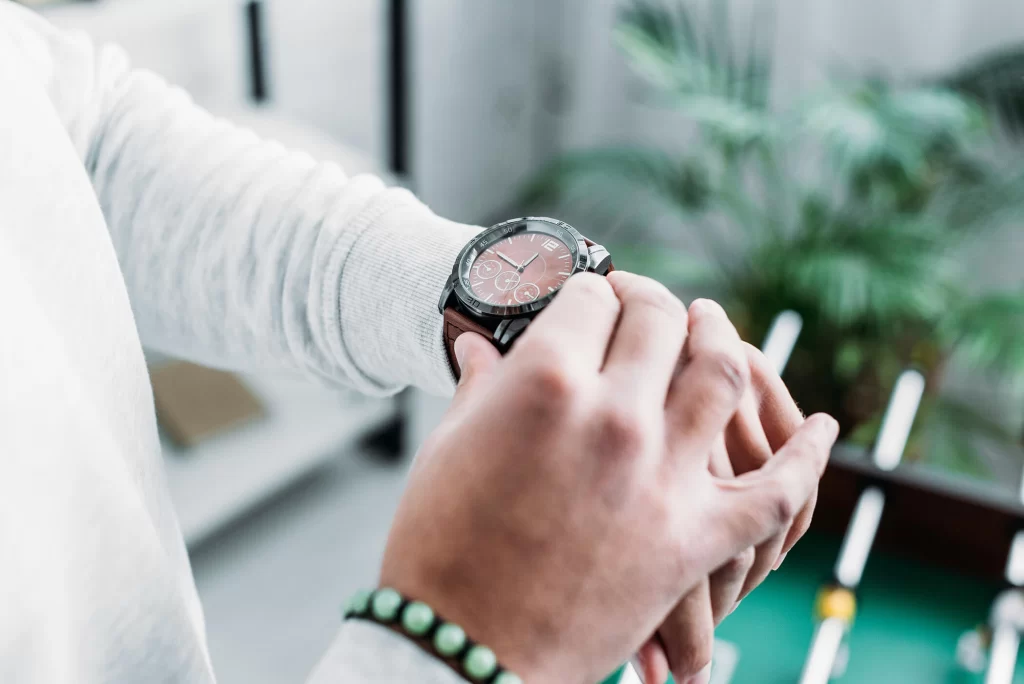 A close-up of a man adjusting his watch