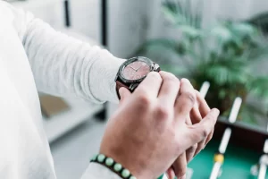 A close-up of a man adjusting his watch