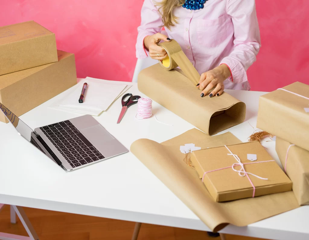 A woman wrapping a box for shipping