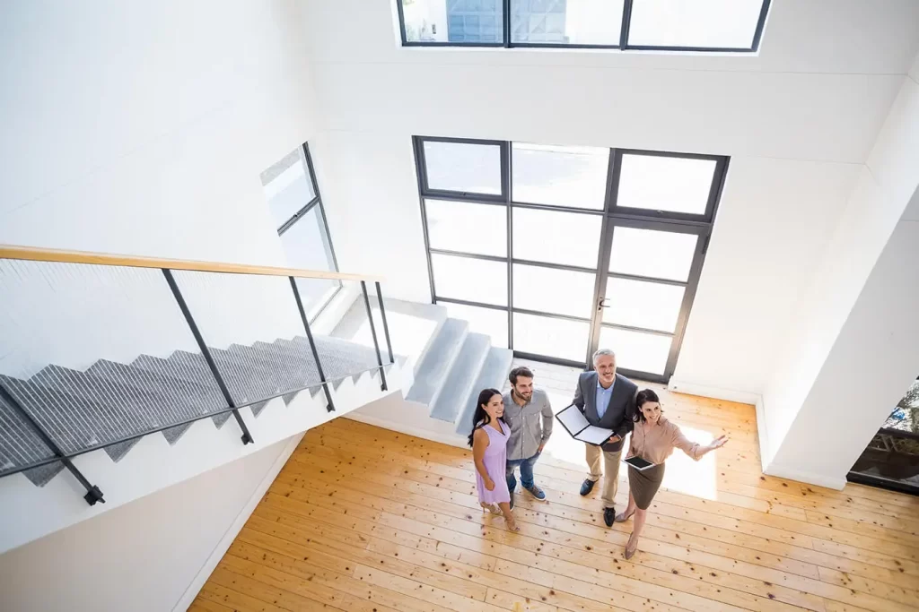Four people standing in an entry way, smiling while looking around
