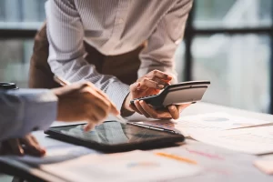 Employees working with a calculator and tablet