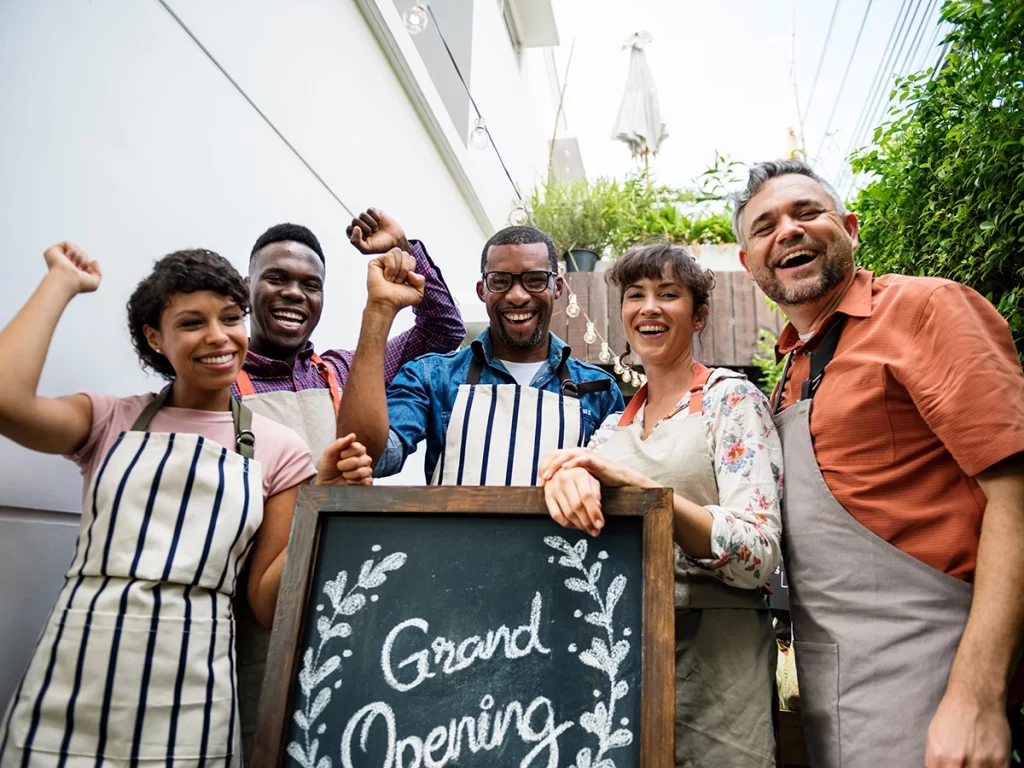 Employees gathered around a "Grand Opening" sign